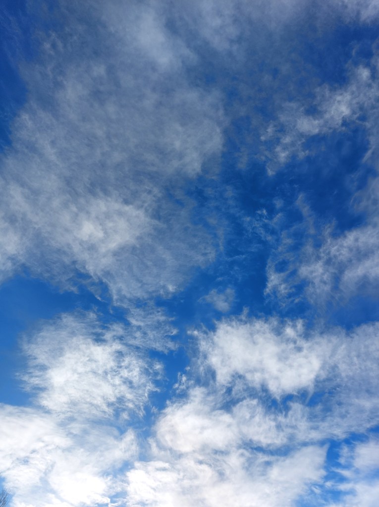 White swirling clouds in a bright blue sky.