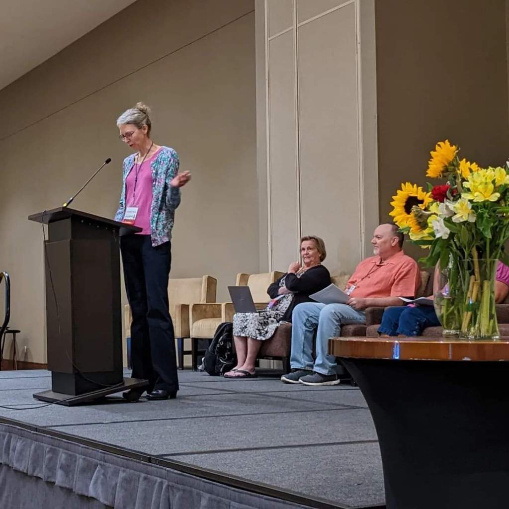 Woman standing at a podium.