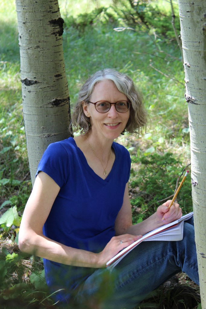 Woman writing in a notebook by a tree trunk.